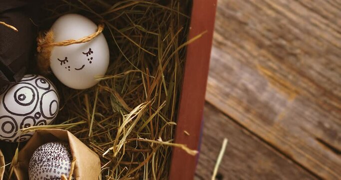 Celebrating Easter, decorated eggs on hay. Close up video of rotating wooden box for christian religious holiday.