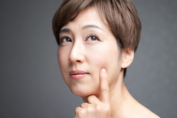 肌のハリを確かめる中年の日本人女性