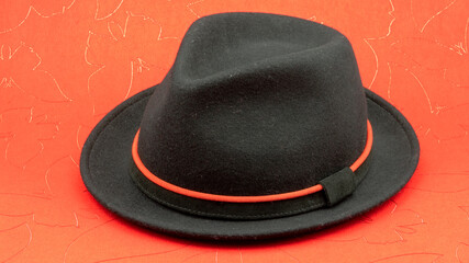 Black pure wool hat on red background