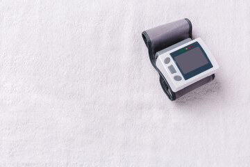 Medical electronic tonometer on a white textile background. Side blank space for ad or text.