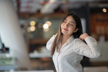 Businesswoman or working lady is stretch themselves or lazily for relaxation on their desk while doing heir work in the office.