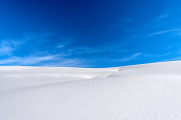 Closeup of a winter landscape with powder snow on blue sky with clouds. Lessinia Plateau (Altopiano della Lessinia), Regional Natural Park, Verona Province, Veneto, Italy, Europe.