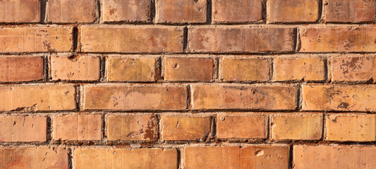 Orange brown damaged rustic grunge brick wall / masonry / brickwork texture background banner wallpaper template