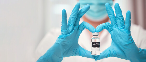 Doctor's hand in sterile medical gloves showing heart shape with vaccine COVID-19