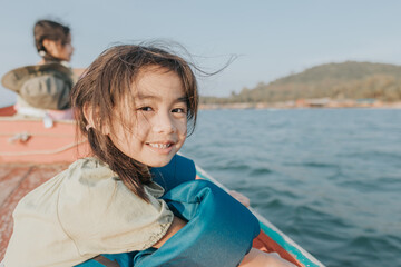 Fototapeta premium child wearing life jacket and sitting in a boat