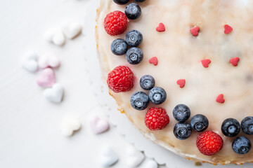 heart love carrot cake mothersday, valentines day, wedding cake with blueberries, raspberries, and heart sprinkles 