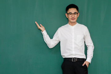Portrait of young and handsome Asian man wearing eyeglasses and casual business clothes, white shirt and black trousers, pose in gestures of advertising and present somethings with self-confidence