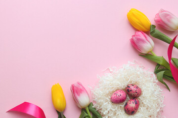 Easter card. Tulip flowers and nest with colored quail eggs on light pink background with copy space. Easter concept, flat lay, top view