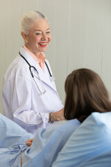 Senior older female doctor visit the patient room and make a history taking for diagnosis and cure process