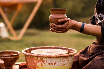 Pottery man hands hold clay pot on his workshop