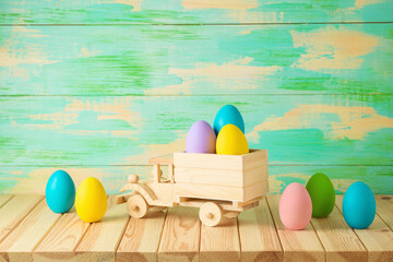 Easter holiday background with Easter eggs and toy truck on wooden table