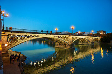 Obraz na płótnie Canvas Isabel II bridge or Triana bridge, in Guadalquivir river at Evening,Sevilla,Andalucía,Spain, Europe.