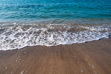 Seascape. Waves running on the sandy shore. Shore of the sea or ocean on a nice day. Vacation and relaxation by the sea.