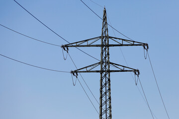 Electricity pylons against blue sky