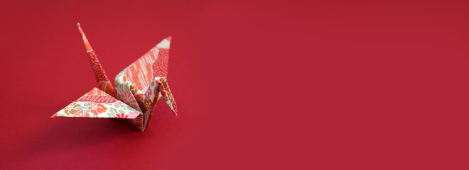 Japanese Origami paper crane on red background