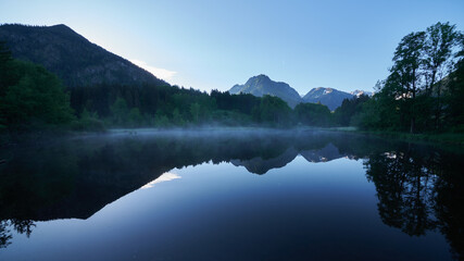 Spiegelungen im Bergsee am frühen Morgen