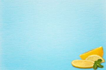 a leaf of blue watercolor paper and in the corner of a two lemon wedge and a half of a lemon and a top green mint