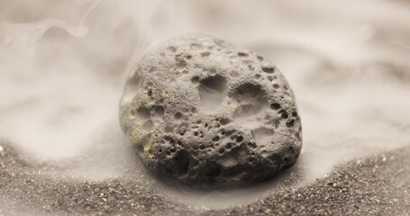 Smoke whirling around small meteorite stone