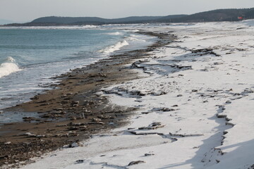 the seashore in the snow. Blue waves on the blue sea. Sea shore. Sand. Summer.