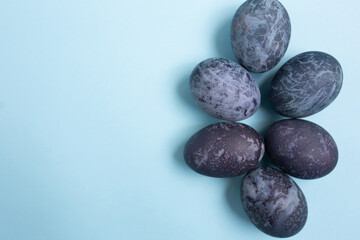 Easter eggs is a marble-blue colour on a blue background with copy space. Happy Easter 2021.