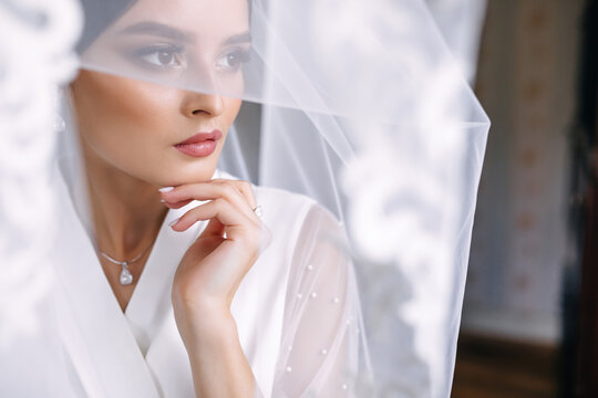 charming bride wrapped in a veil. Wedding morning.
