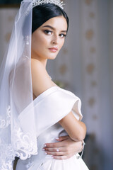 Morning of the bride. A slender woman in a wedding dress. Amazing girl with beautiful makeup.