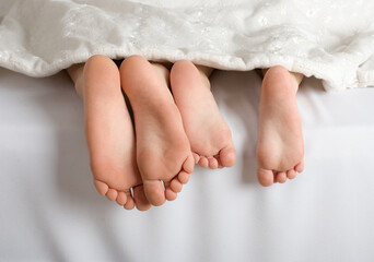 small feet of children under the covers