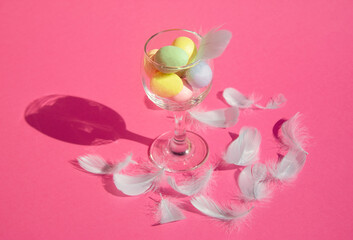 Creative Easter cocktail made of eggs and feathers on pink background. Happy Easter 2021.
