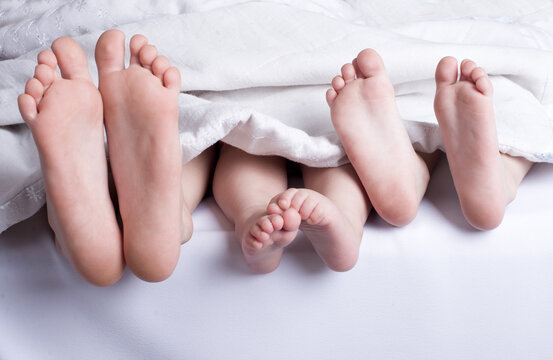 small feet of children under the covers