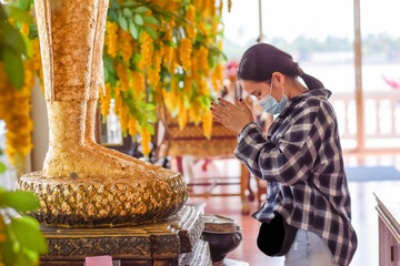 Beautiful girl paying respect to buddha statue