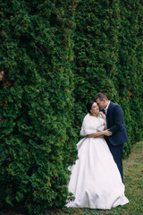 Stylish couple of happy newlyweds walking in the garden on the w