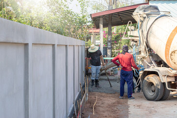 The cement truck was pouring the cement into the area and the mechanic was controlling and...