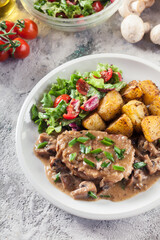 Pork loin chop with mushroom sauce and baked potatoes