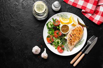 Grilled chicken breast with fresh vegetable salad. Healthy food, keto diet, diet lunch concept. Top view on black stone background