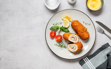 French traditional cuisine crispy, creamy chicken cordon bleu on gray background. top view. space for text