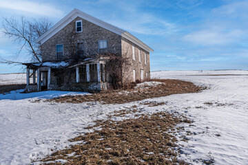 Winter landscape with abandoned limestone house.
