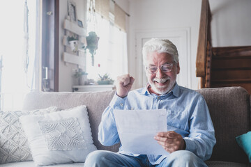 Excited elderly man celebrate health insurance deal closing looking and reading the medical results. Happy mature senior feel overjoyed make sign good bank agreement with specialist. Checking outcomes