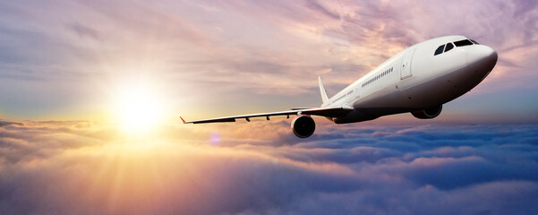 Fototapeta na wymiar Passenger jetplane flying above clouds in sunset