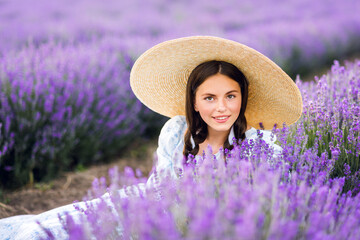 Portrait of a beautiful girl on a lavender background. A young model. Summer photo in the sun