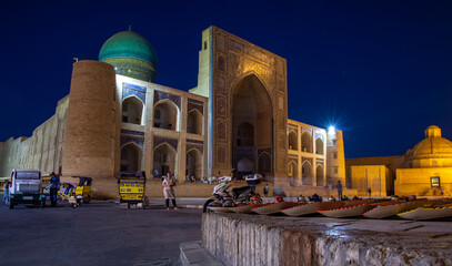 view of the middle east city central square in the night with madrasah and mosque 