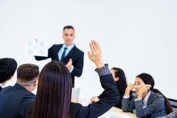 Fototapeta premium Asian woman's back pie Raise your hand to give you an idea. Blur the back is someone who wants an idea or a leader within a meeting..