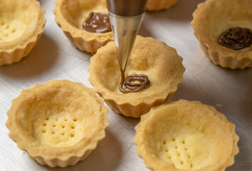 Piping cheese tarts fillings. Selective focus.