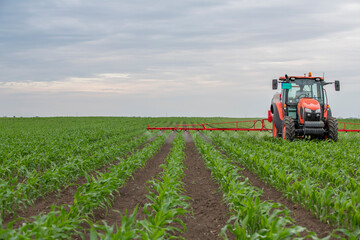 Tractor spraying pesticides at corn fields