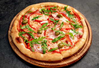 pizza with ham, tomatoes, cheese on a stone background