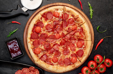pepperoni pizza with ingredients on stone background