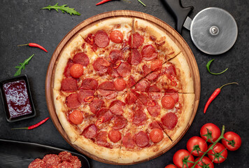 pepperoni pizza with ingredients on stone background