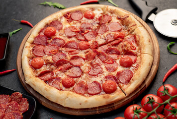 pepperoni pizza with ingredients on stone background