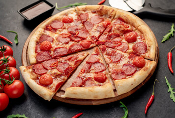 pepperoni pizza with ingredients on stone background
