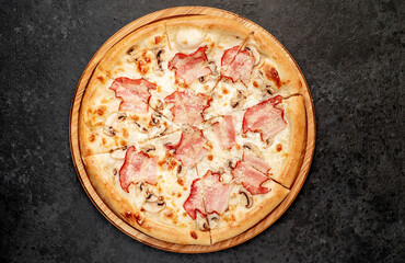 pizza with bacon, mushrooms and cheese on a stone background