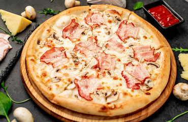 pizza with bacon, mushrooms and cheese on a stone background